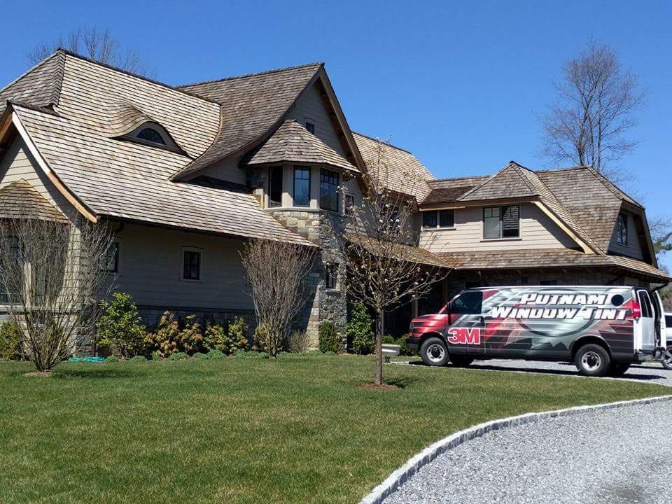 A van parked in front of a house with a bunch of trees