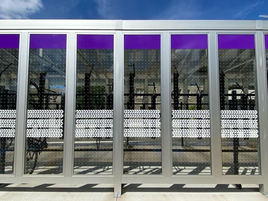A bench sitting in front of a building with purple walls.
